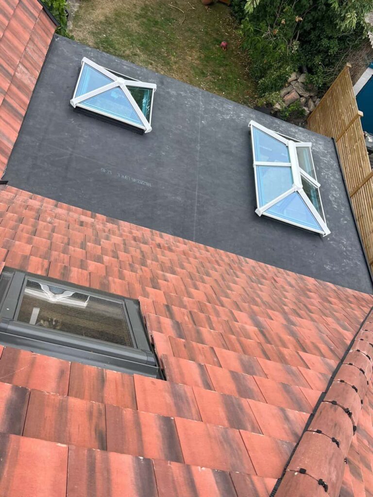 This is a photo taken from the roof ridge looking down a tiled pitched roof on to a flat roof. Works carried out by MCM Roofing Repairs Verwood